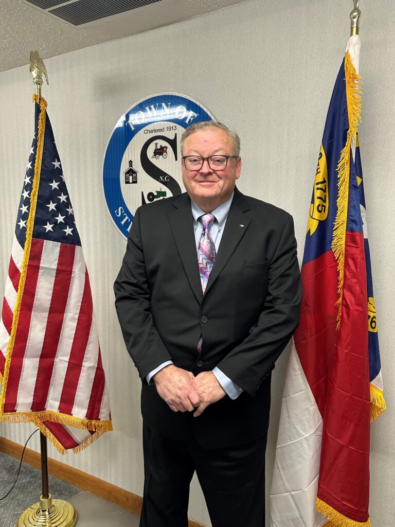 Photo of Town Commissioner standing in front of the Town of Stedman seal.