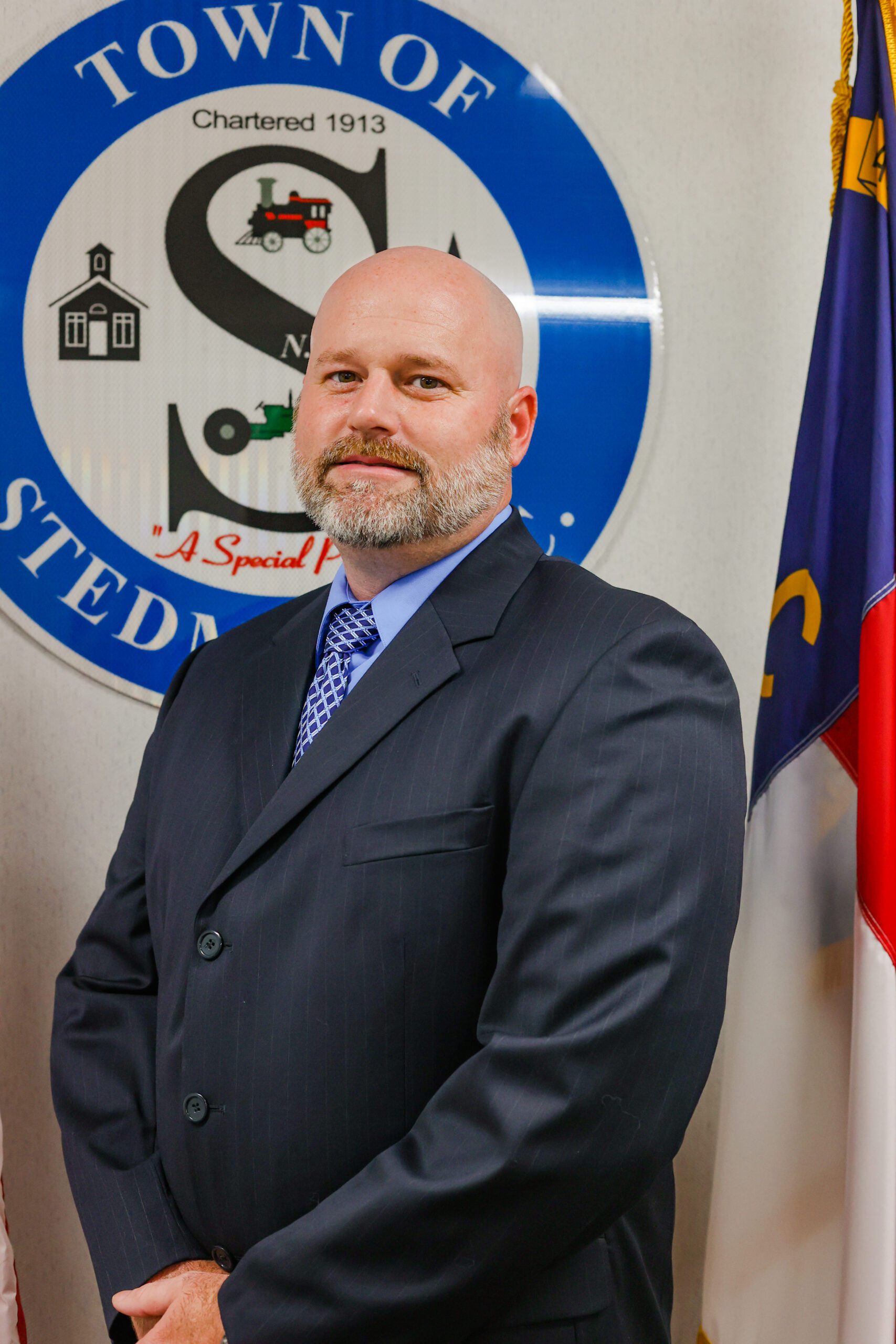 Photo of Town Commissioner standing in front of the Town of Stedman seal.