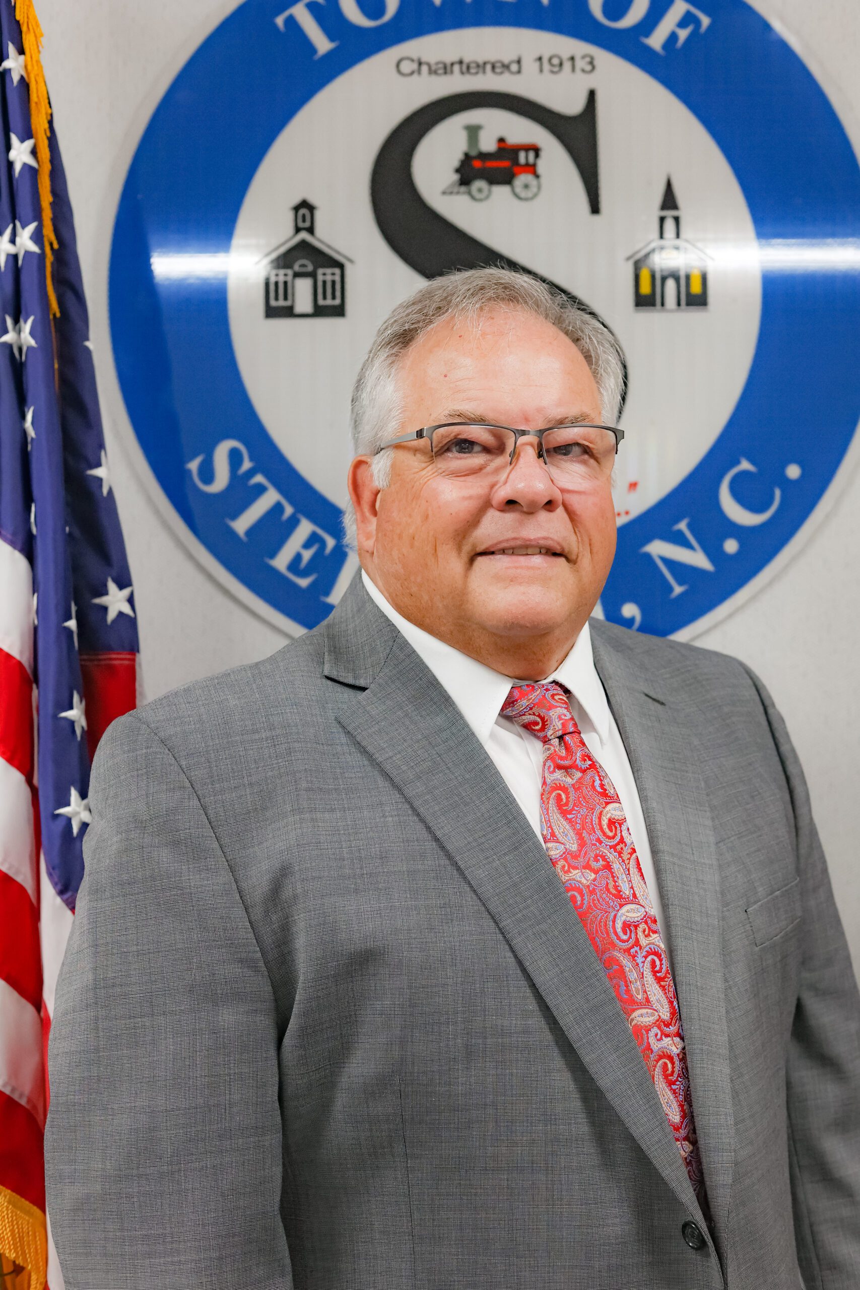 Photo of the Town's Mayor standing in front of the Town of Stedman Seal.