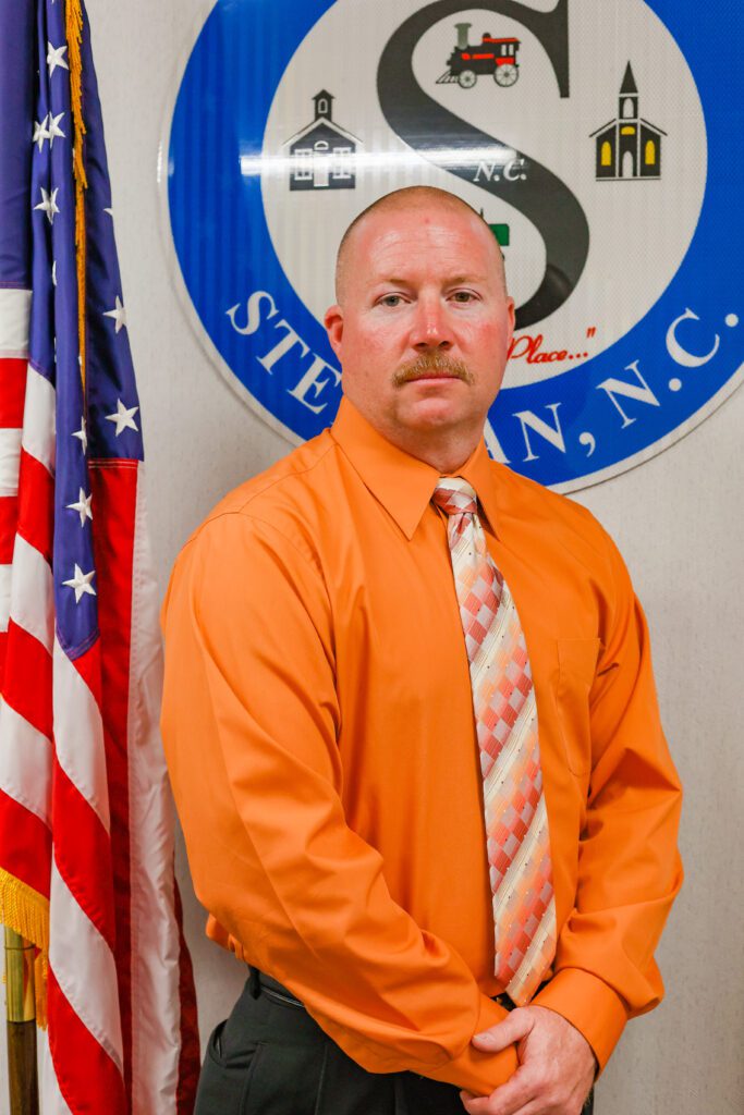 Photo of Town Commissioner standing in front of the Town of Stedman seal.